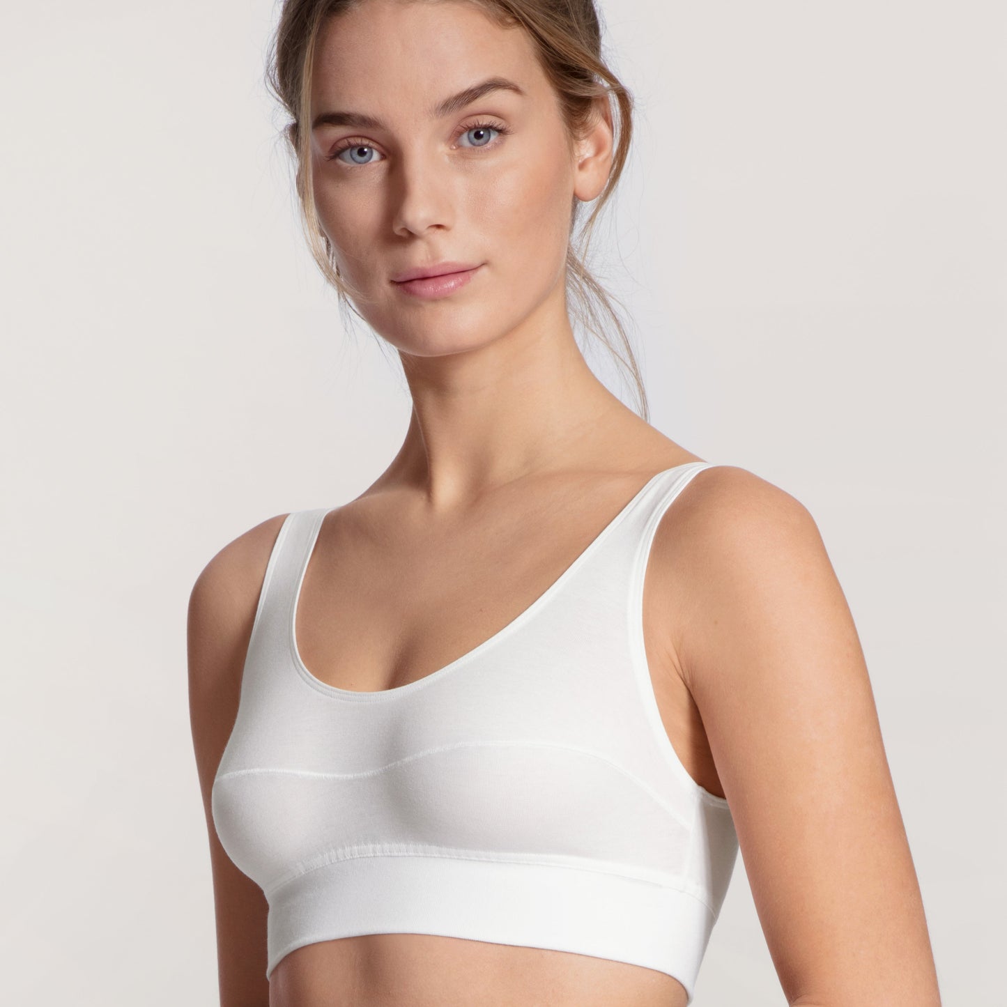 Two models, one in a white and one in a black bralette, posing on a neutral background.