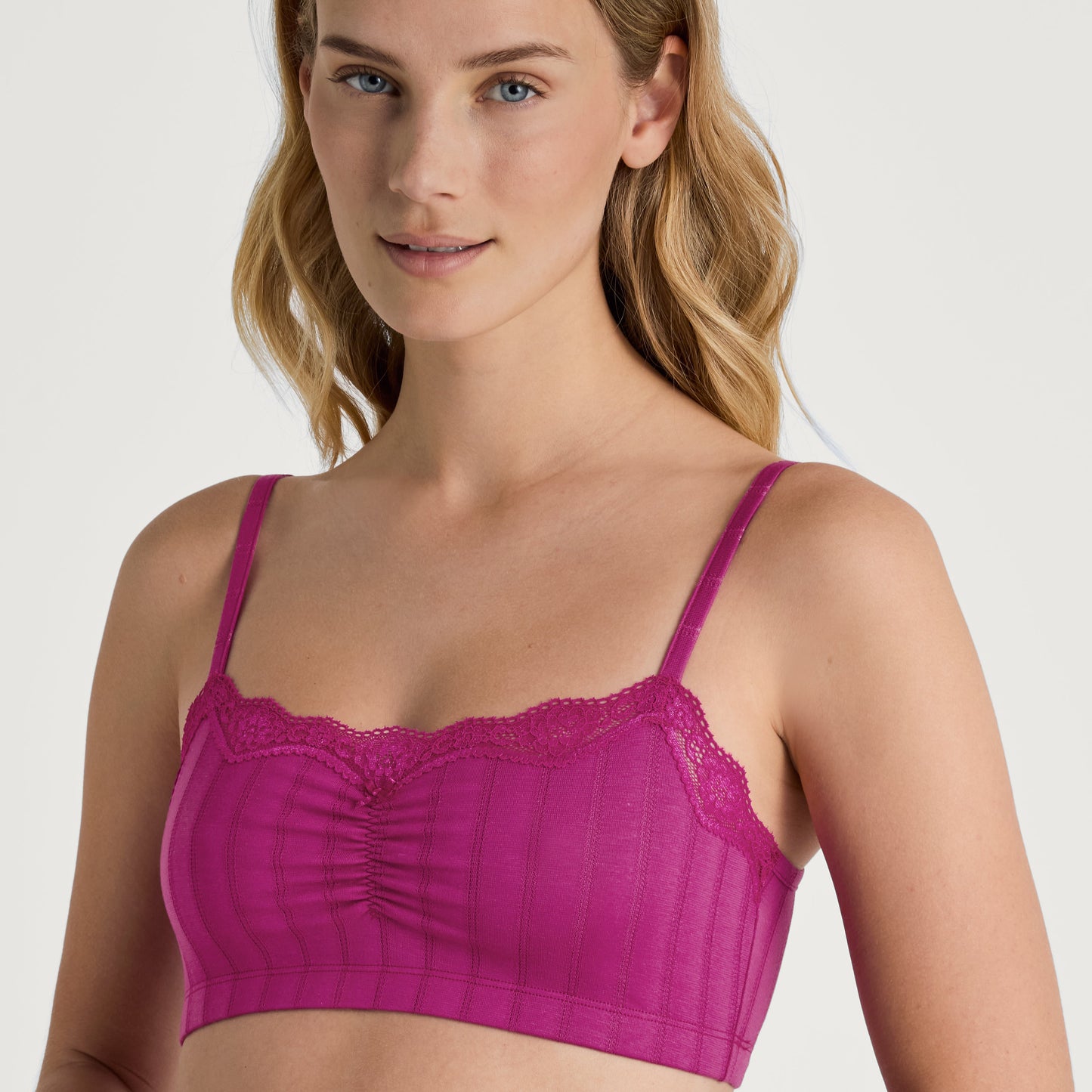 A woman wearing a magenta bralette with a jacquard look design.