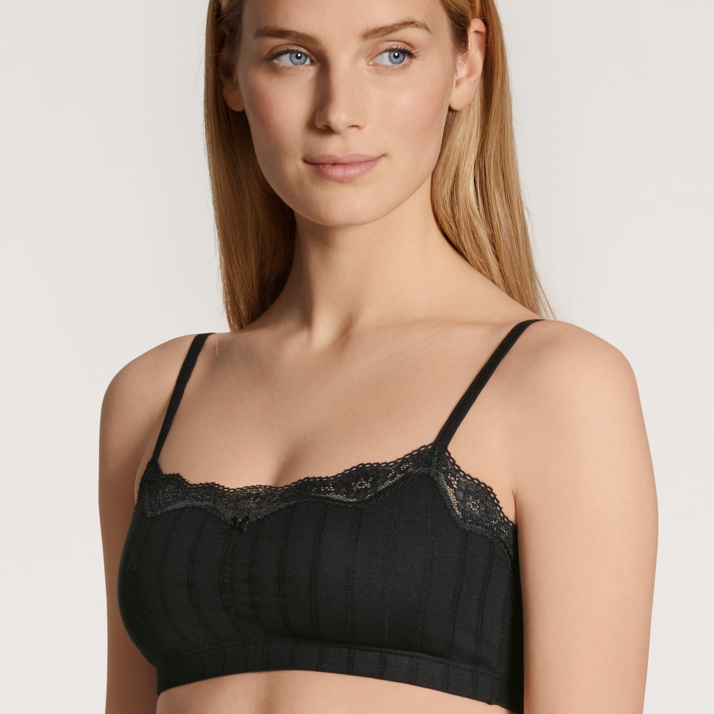 A woman wearing a white bralette with a jacquard look design.