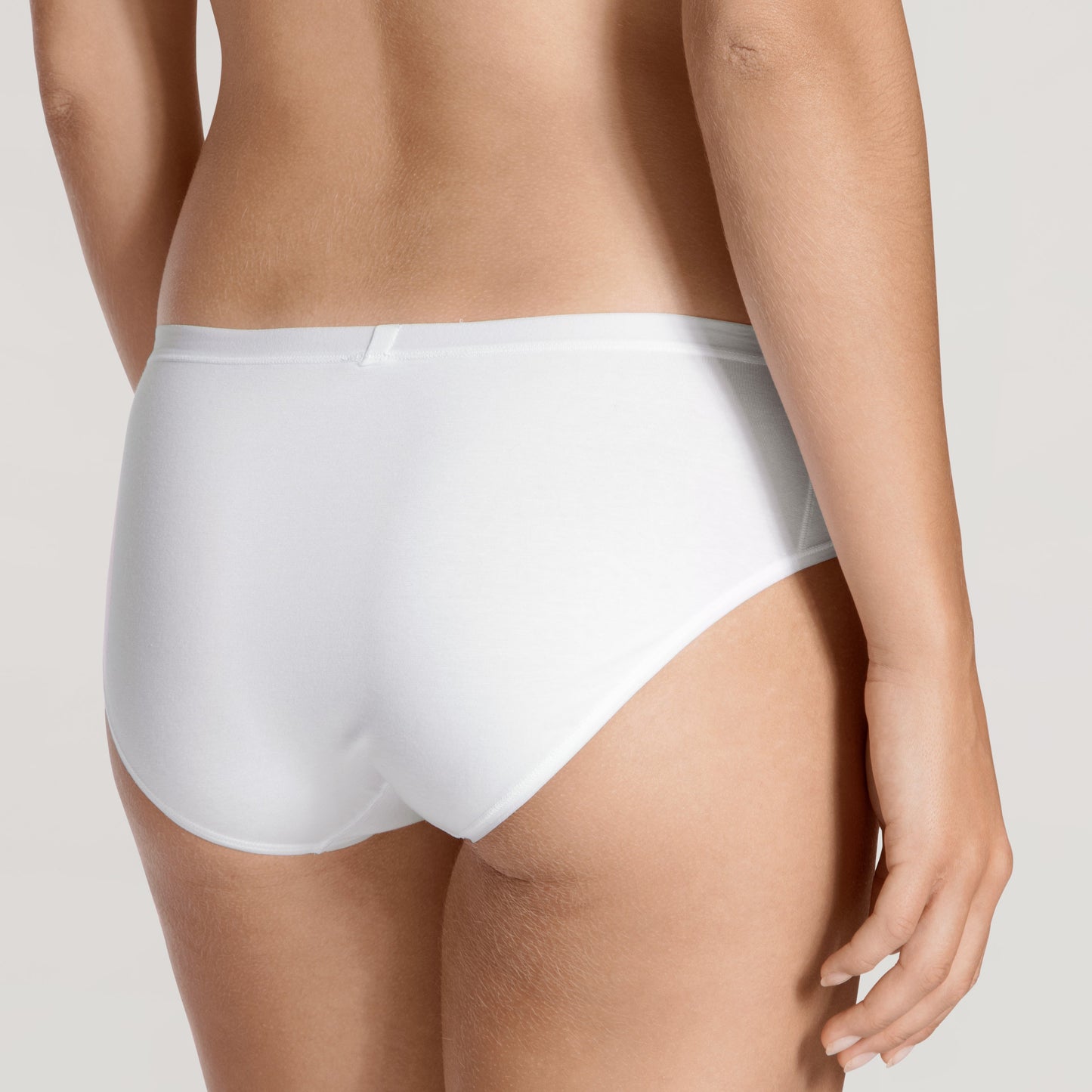 White underwear worn by a person on a light gray background