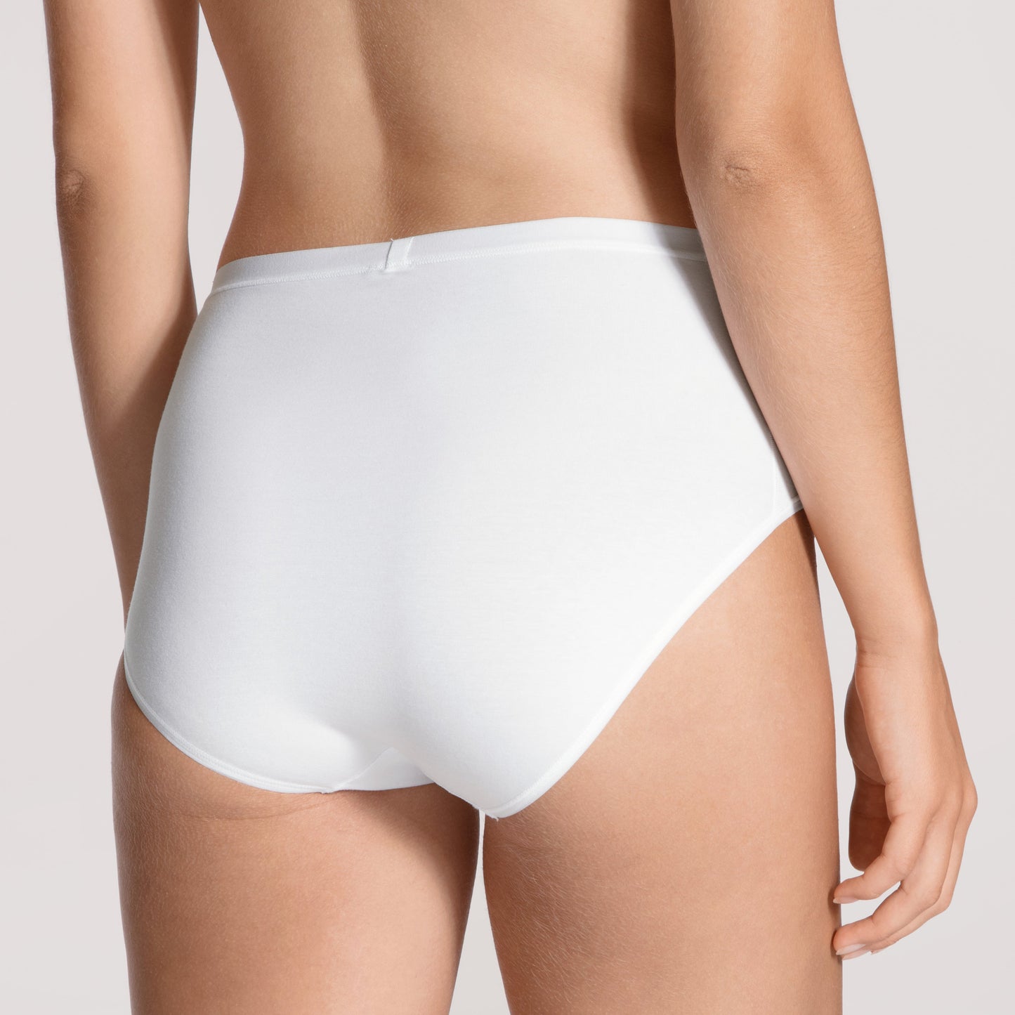 White high-waisted underwear worn by a person on a light gray background