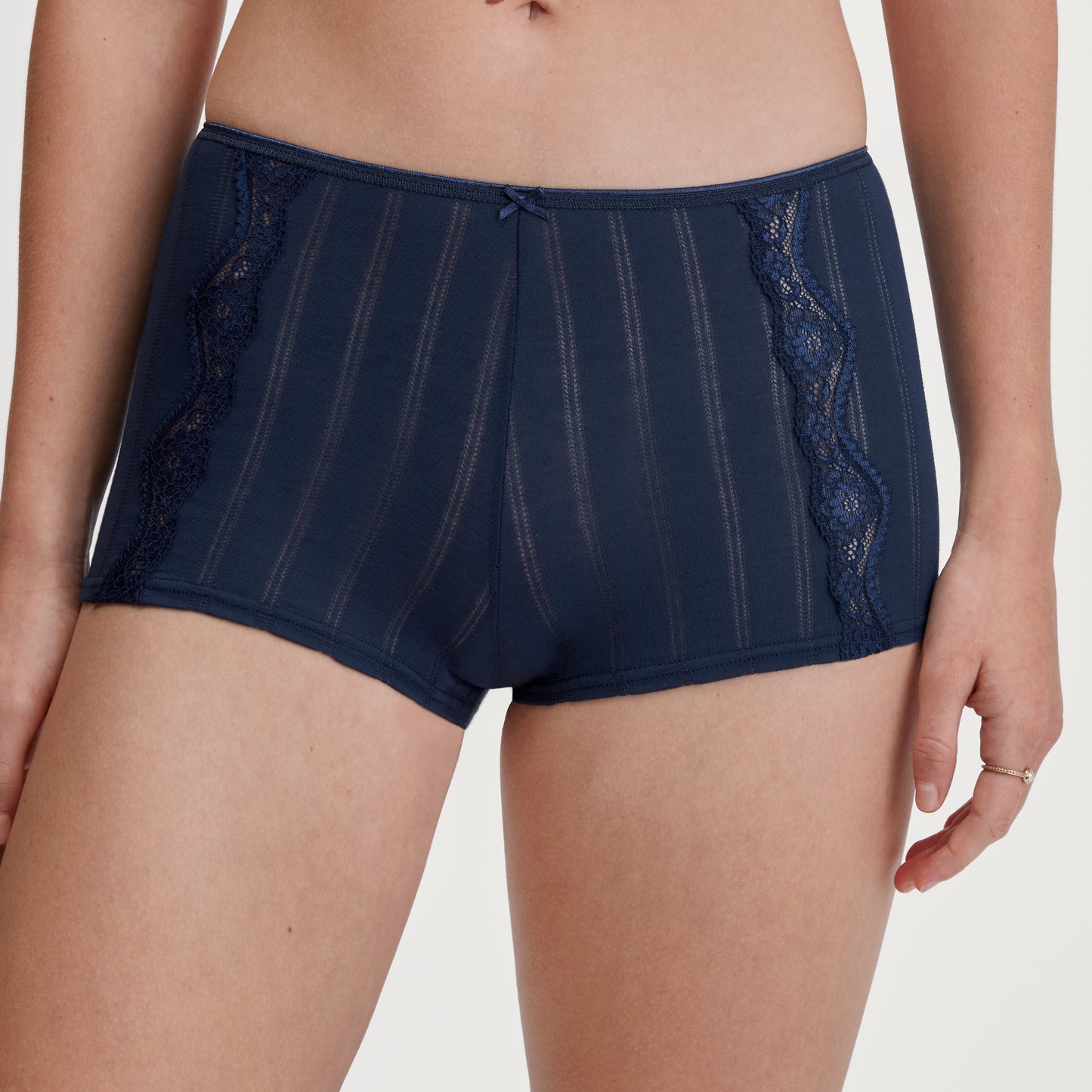Navy blue lace-trimmed underwear on a plain background
