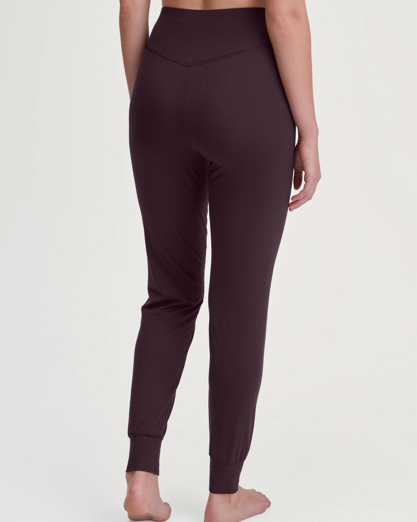 Dark plum leggings worn by a person on a white background