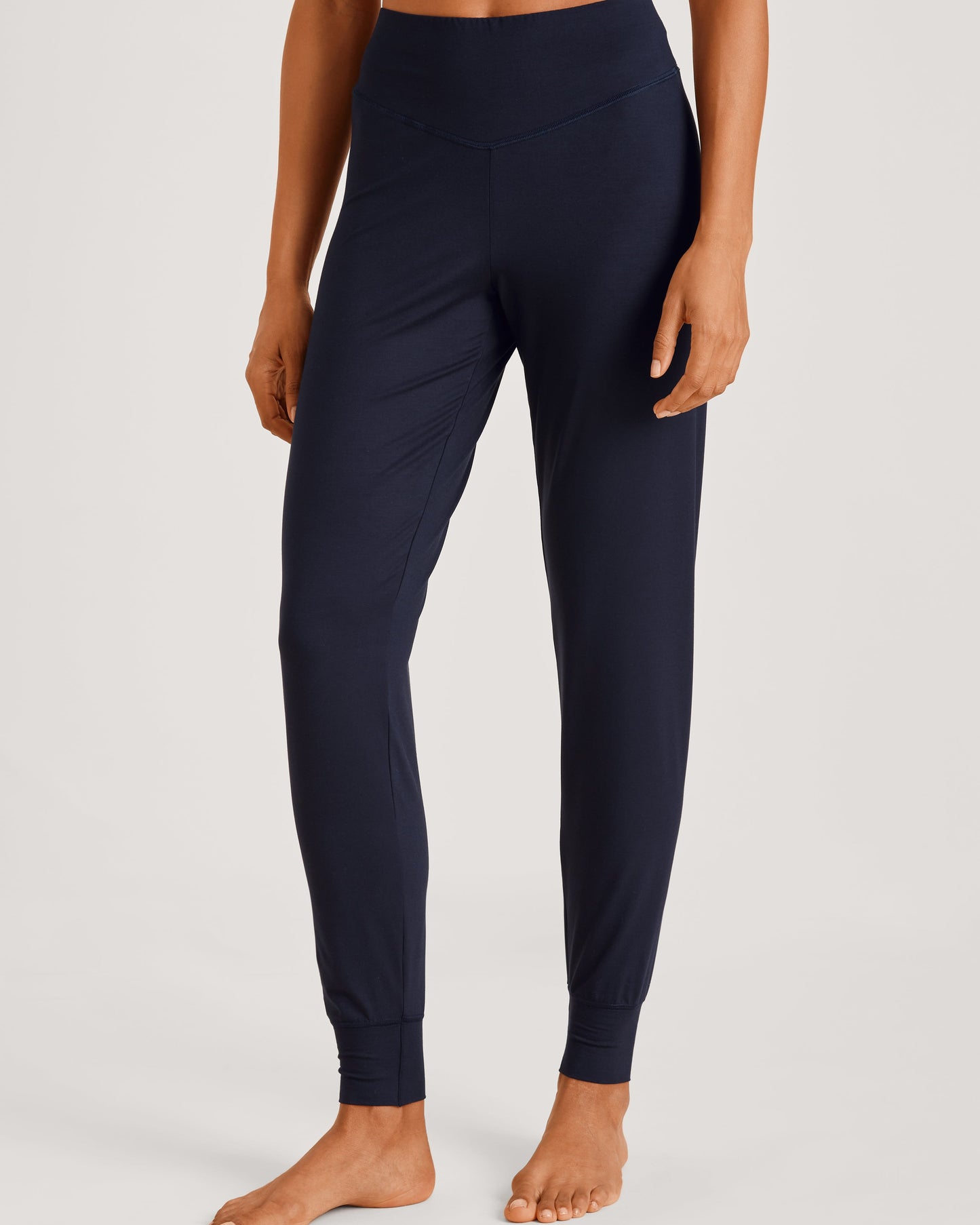 Person wearing navy blue leggings on a light gray background