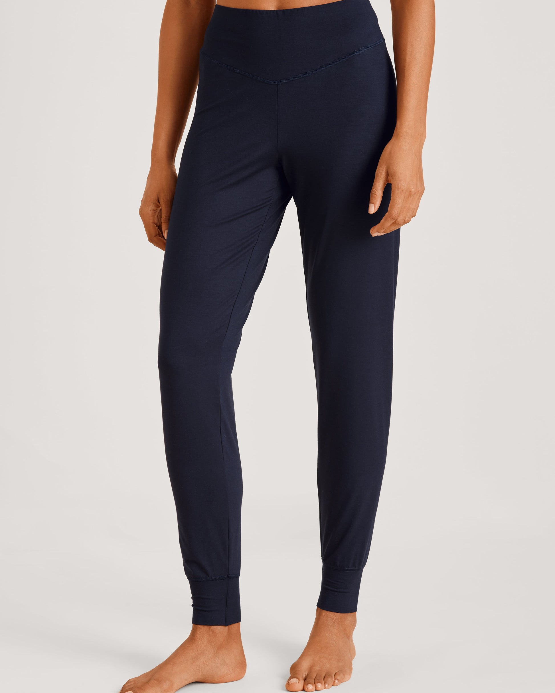Person wearing navy blue leggings on a light gray background