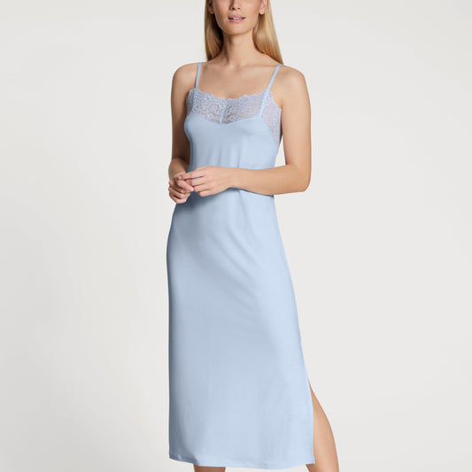 Woman wearing a light blue nightgown on a white background