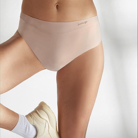 Person wearing beige underwear with a white background