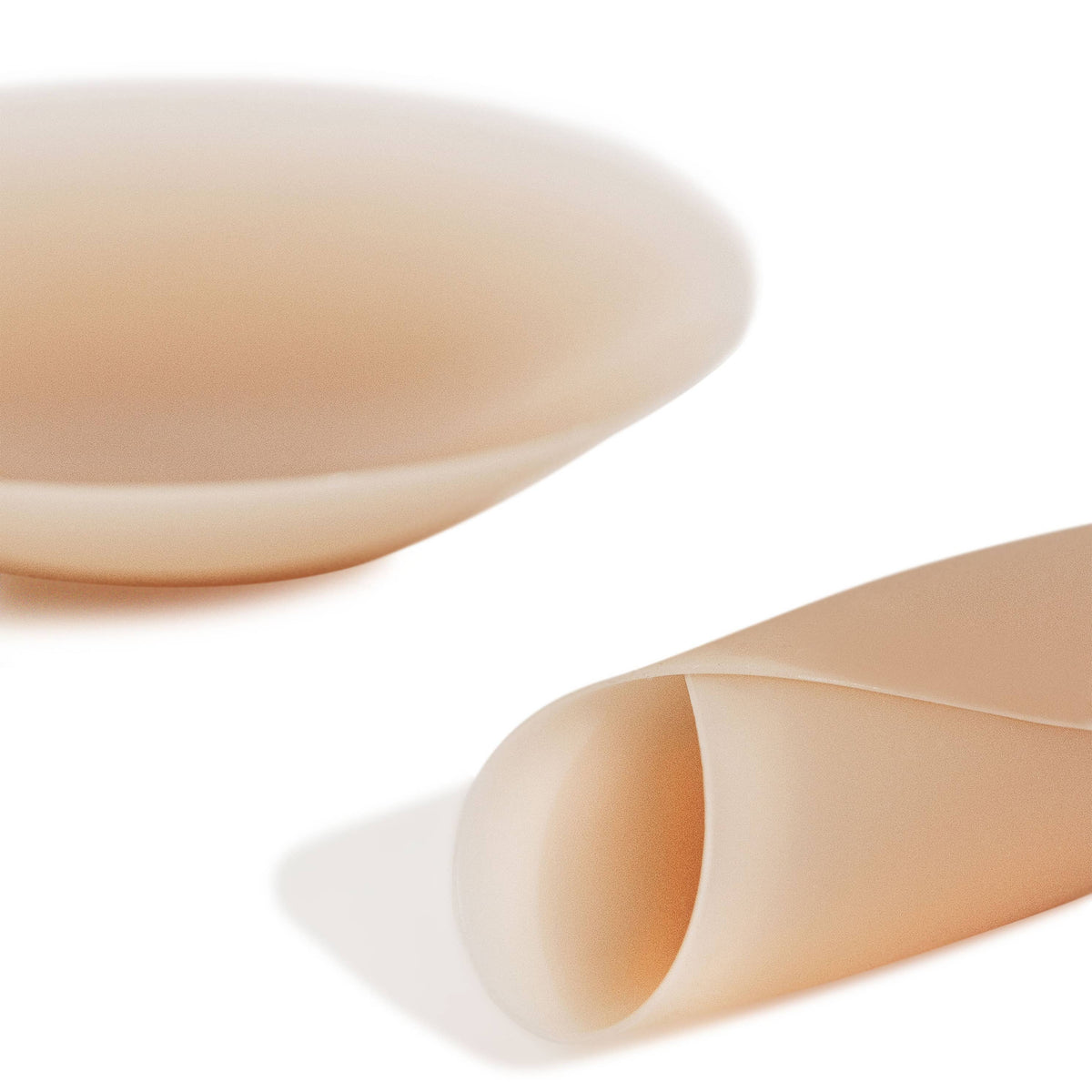 Two beige-colored bandage rolls on a white background
