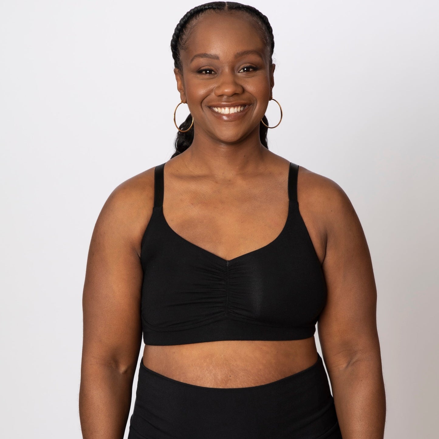 Person wearing a black sports bra and leggings on a white background
