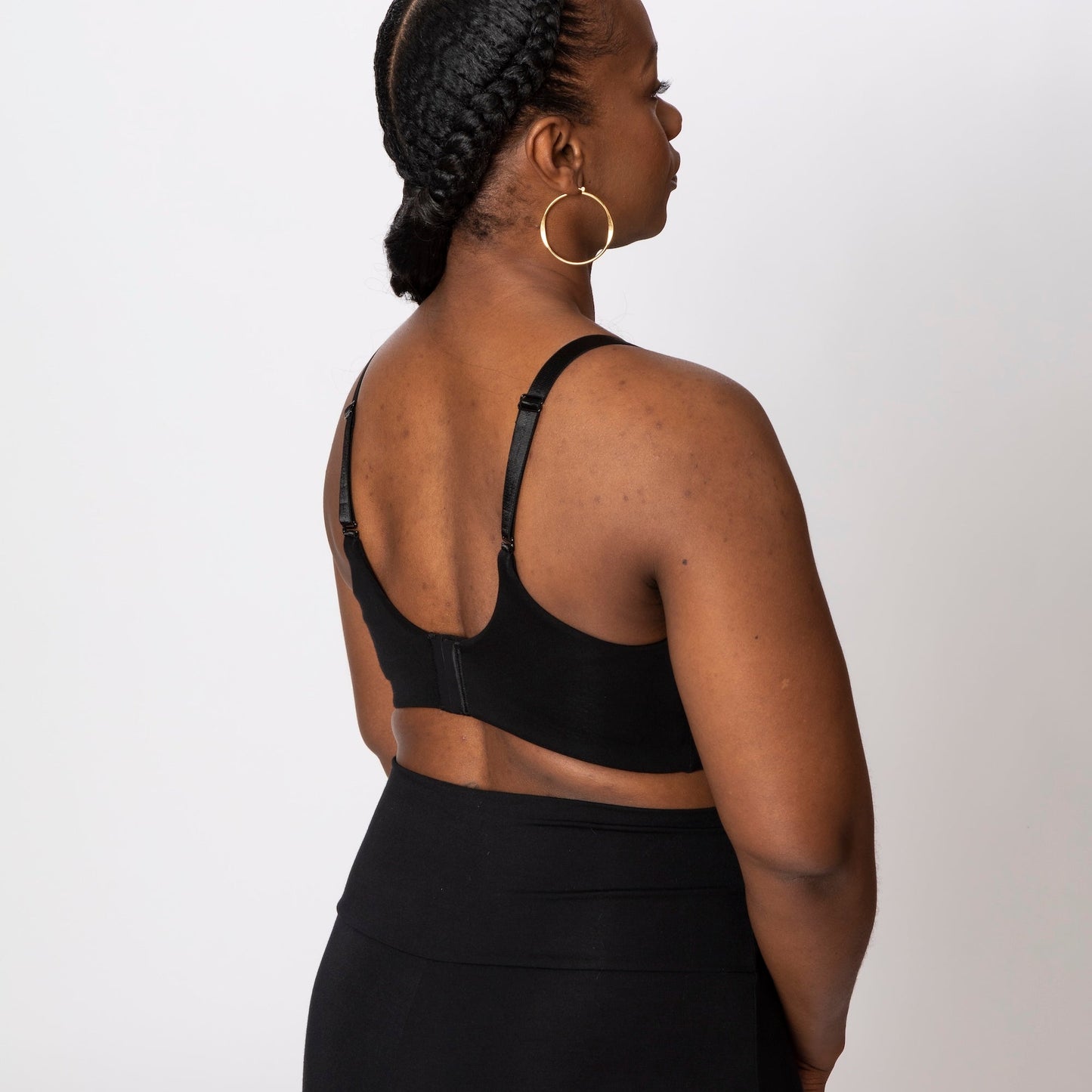 Person wearing a black outfit with cut-out design on a white background