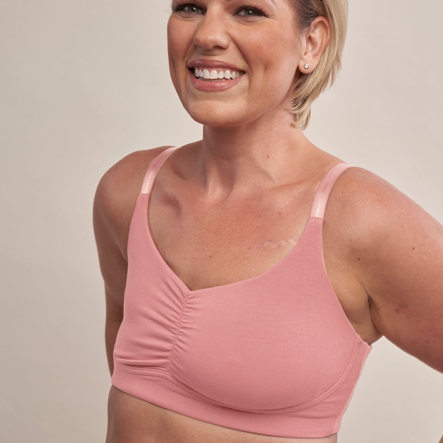 Woman wearing a pink sports bra against a neutral background