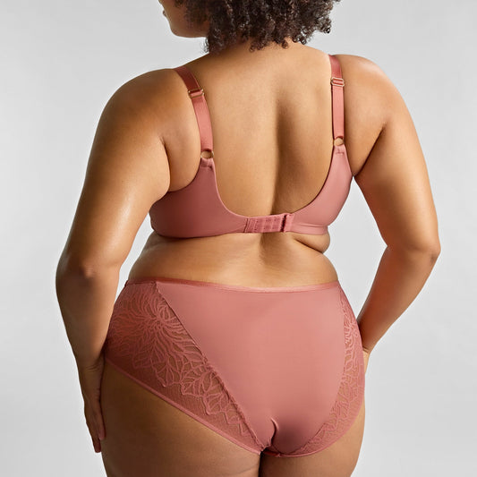 Person wearing a pink lingerie set against a plain background