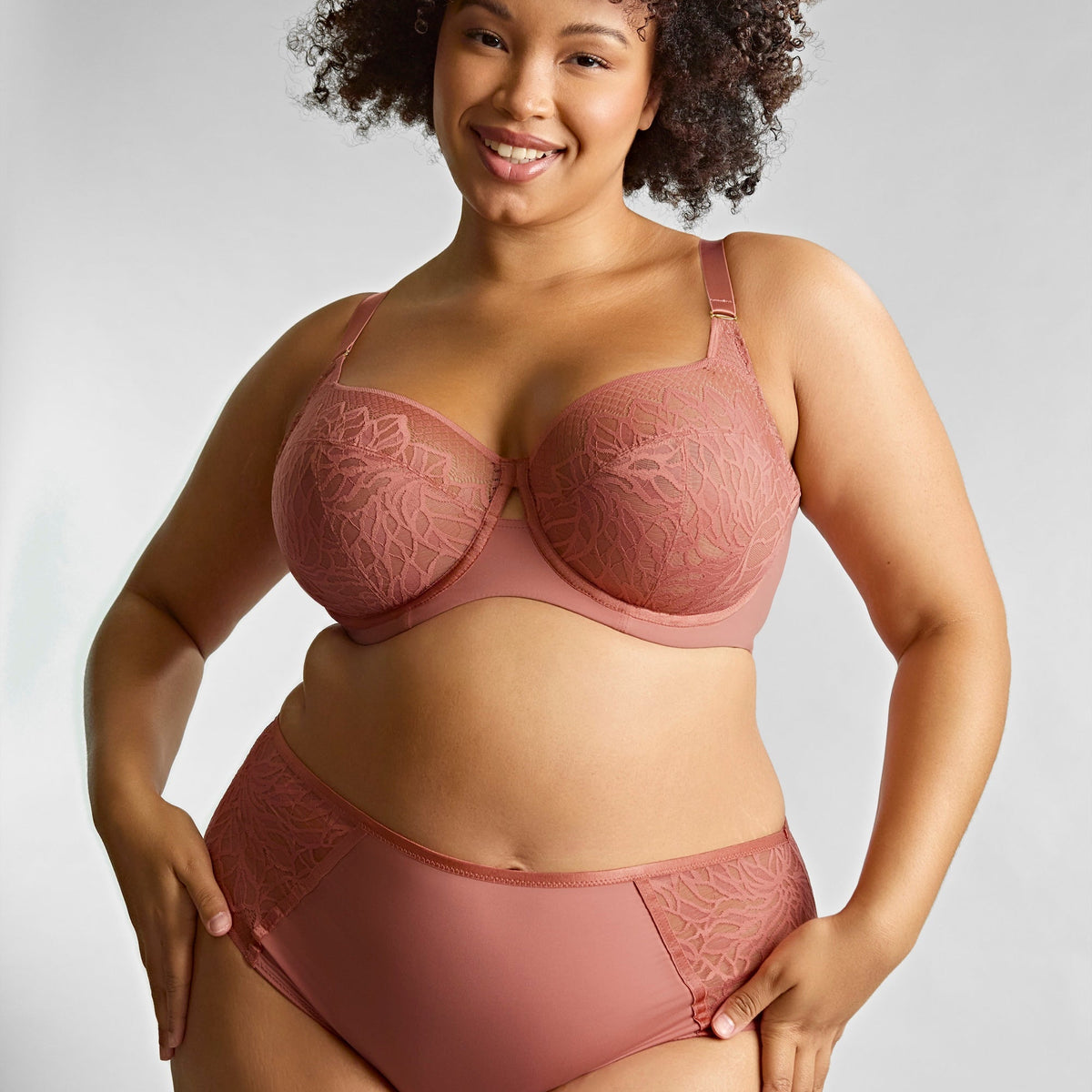 Woman wearing a brown lingerie set against a plain background