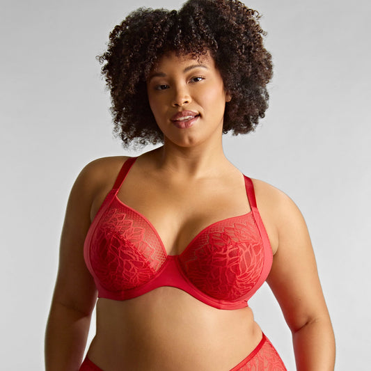 Woman wearing a red bra and panties set against a plain background