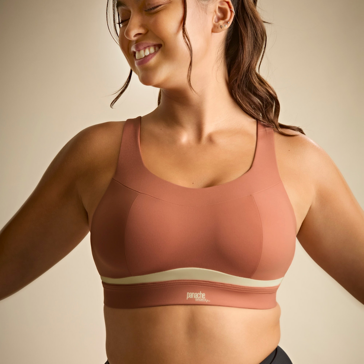 Woman wearing a brown sports bra with a beige background