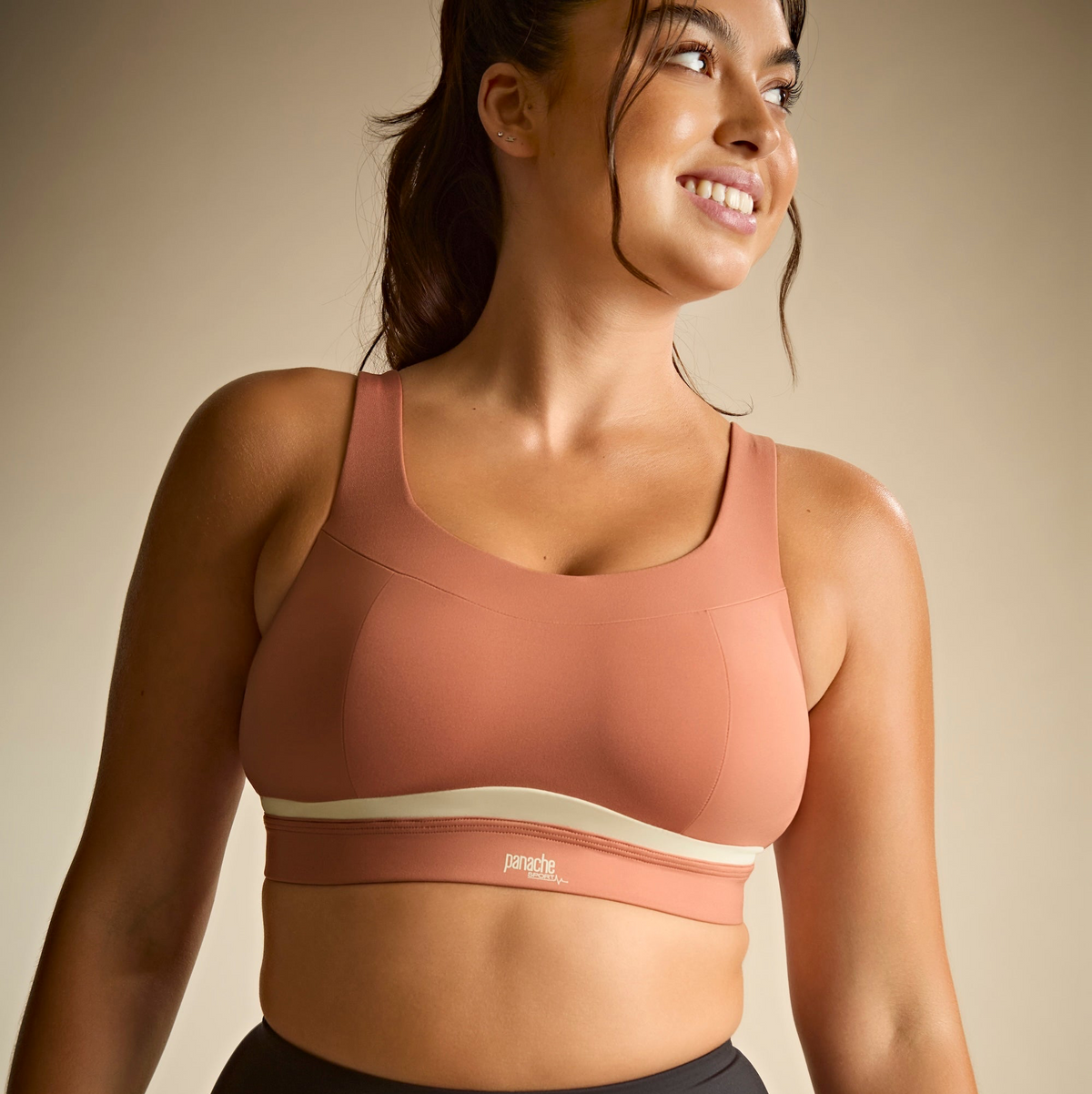 Woman wearing a pink sports bra with a beige background