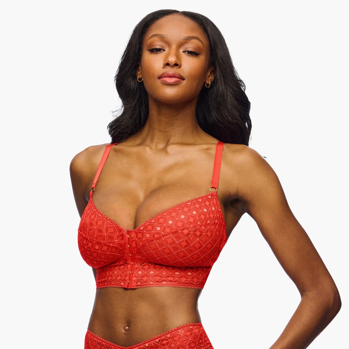 Woman wearing a red lace bikini set on a white background