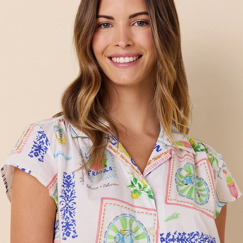 Woman wearing a colorful patchwork shirt with a beige background