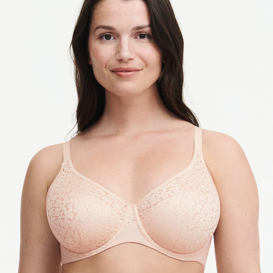 A woman wearing a pink underwire bra with floral details.