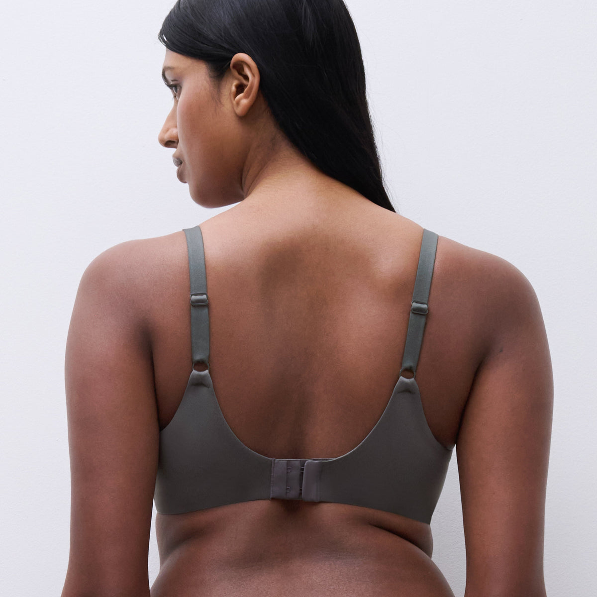 Woman wearing a gray sports bra and leggings on a white background