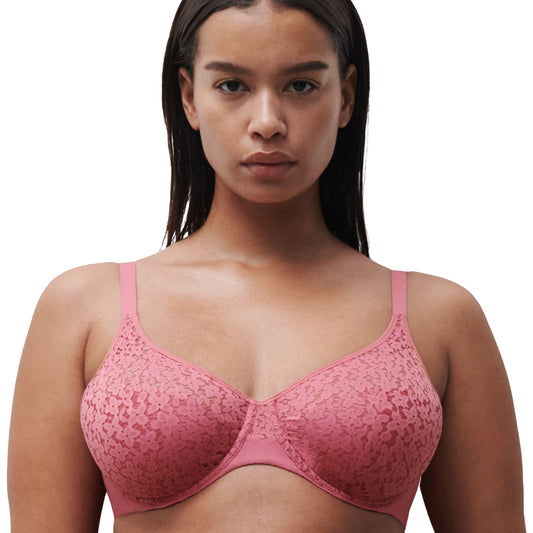A woman wearing a pink underwire bra with floral details.