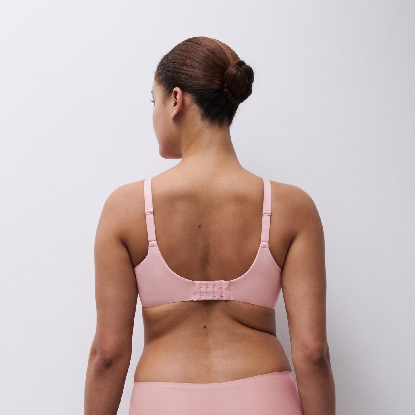 Person wearing a pink bikini set against a plain background