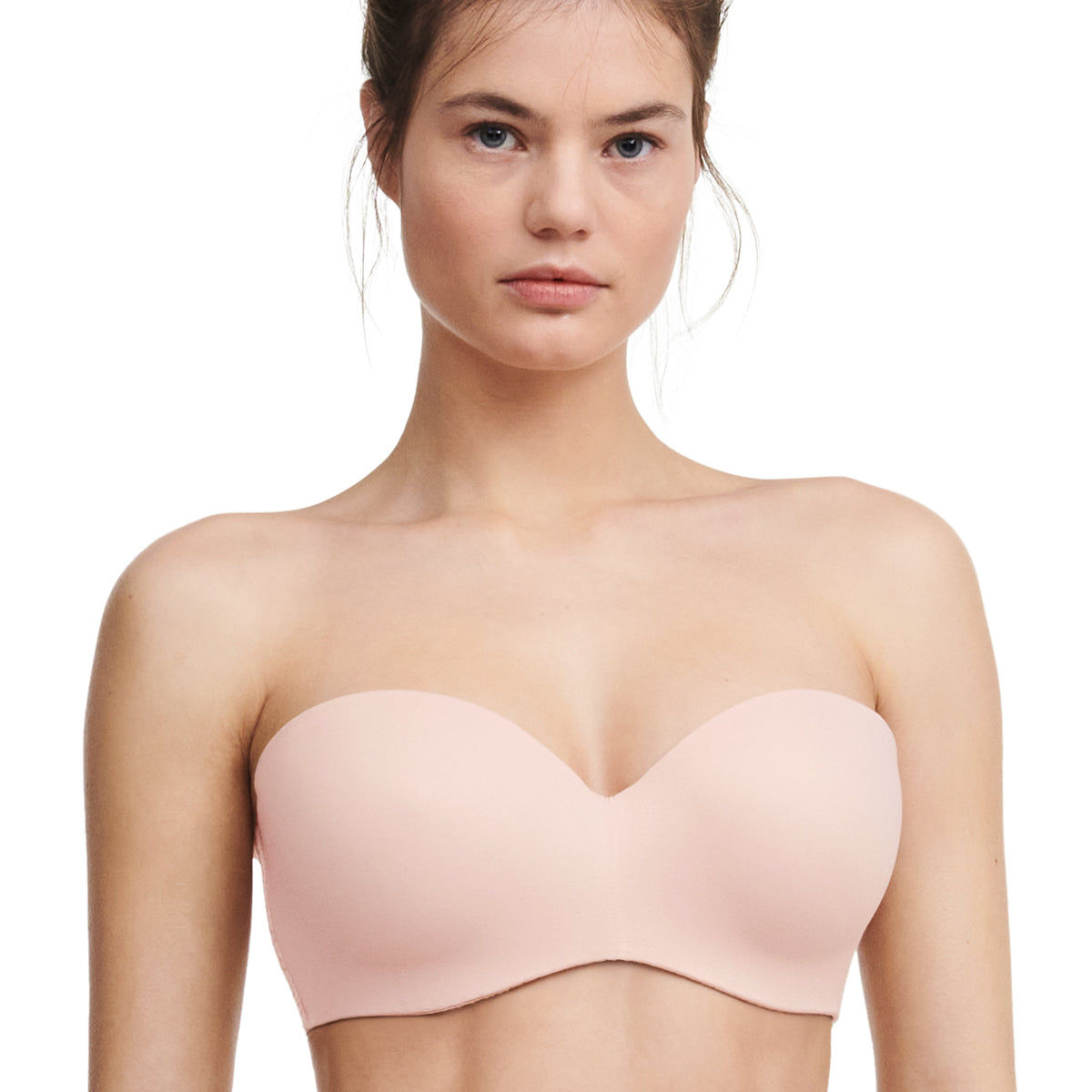A strapless convertible bra in a nude rose color, displayed on a model.