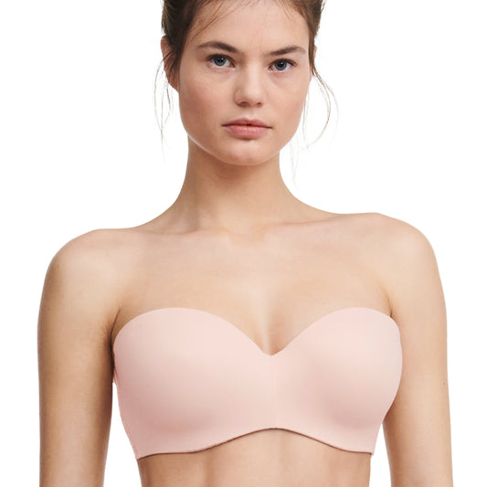 A strapless convertible bra in a nude rose color, displayed on a model.
