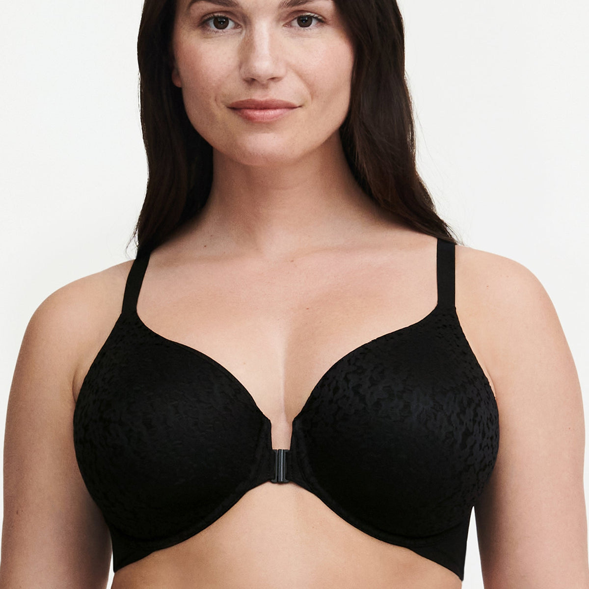 A woman wearing a black front closure bra with floral details.
