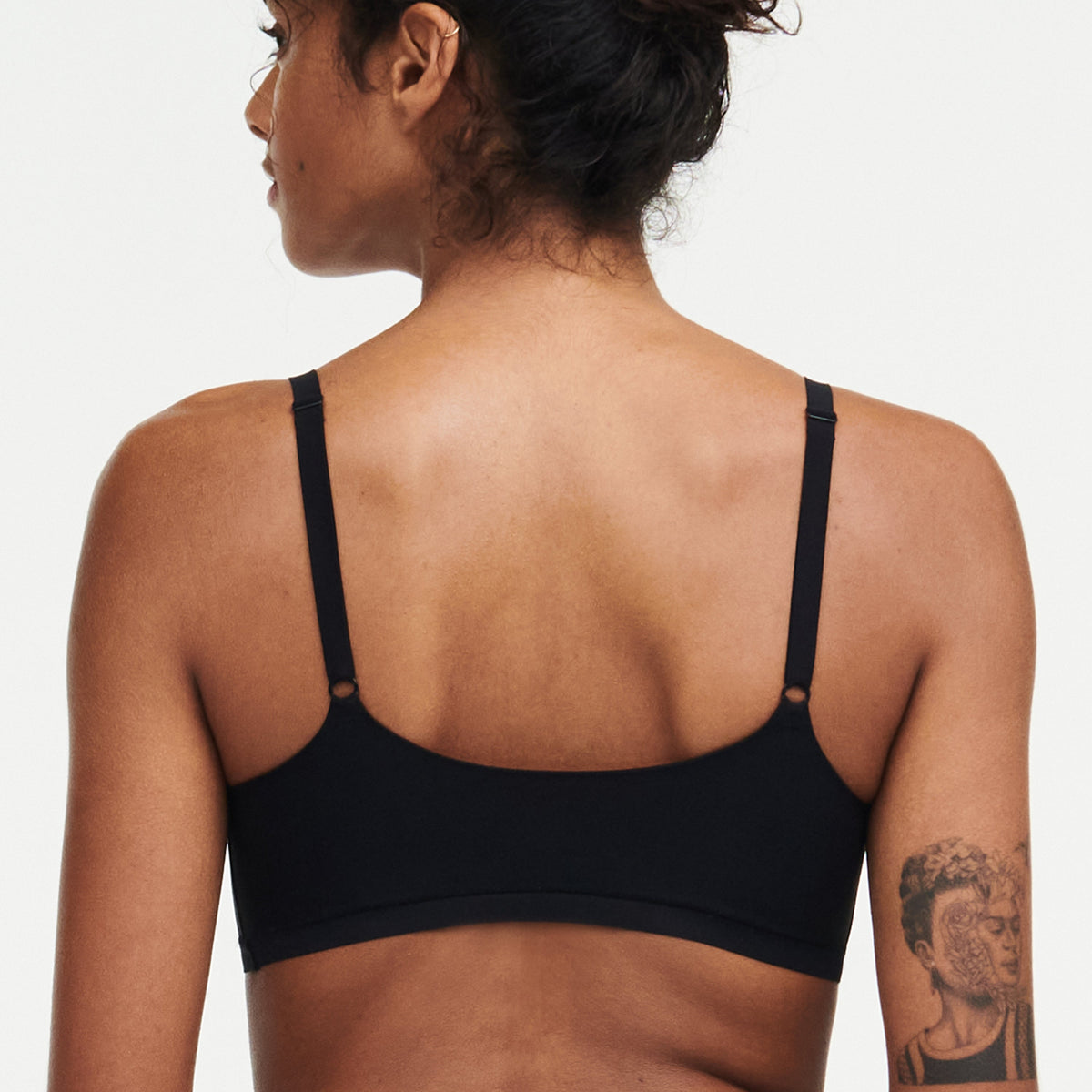 Person wearing a black sports bra on a plain background