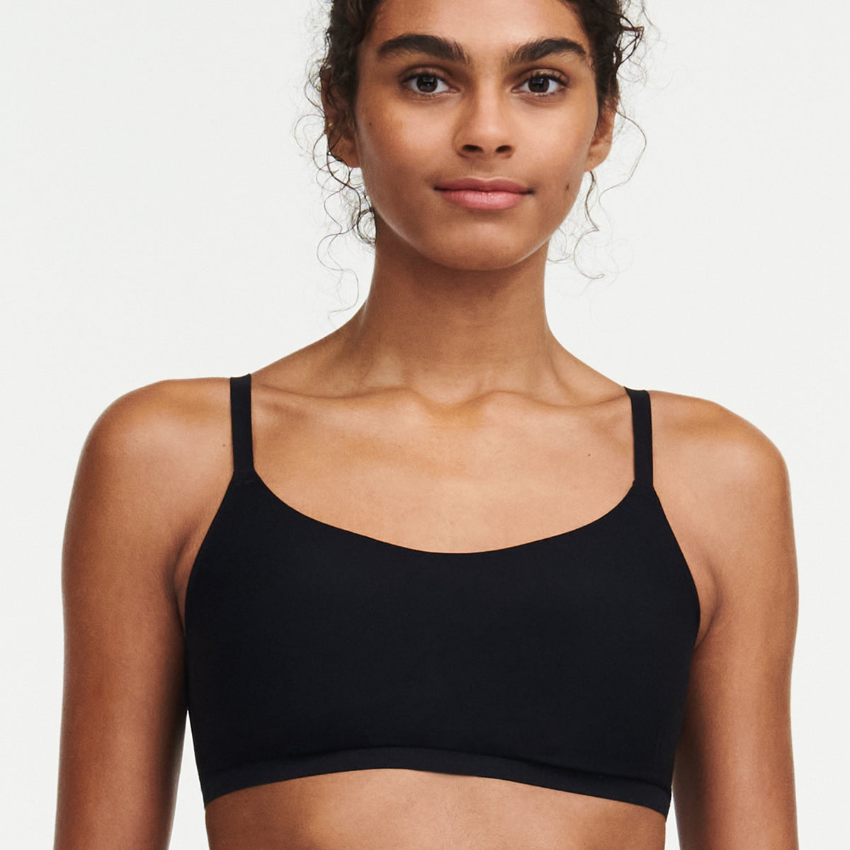 A woman wearing a black scoop padded bralette.