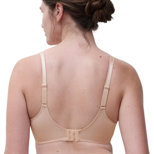 Woman wearing a beige back support brace on a white background