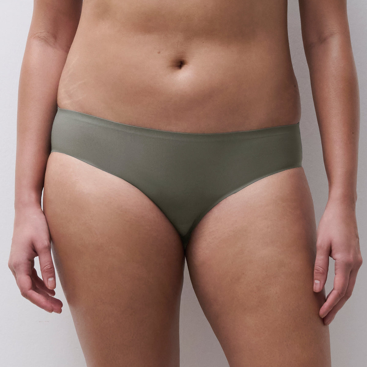 A model wearing a pair of solid olive green bikini bottoms, shown from the waist to the upper thighs against a plain light gray background.