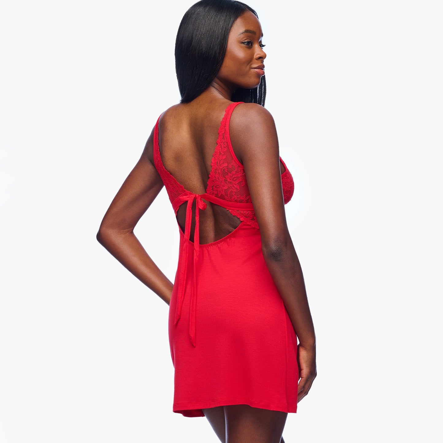 Woman wearing a red dress with a lace back on a white background