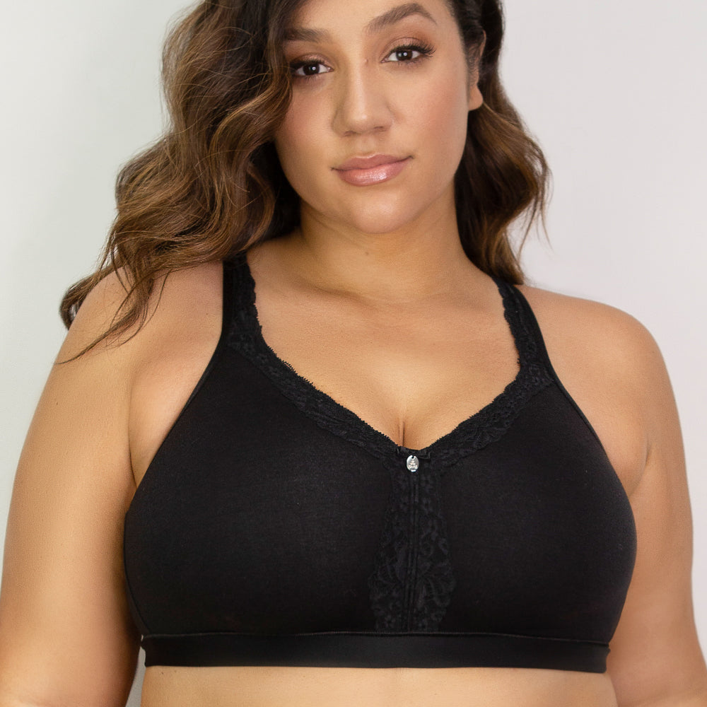 Woman wearing a black bralette against a plain background