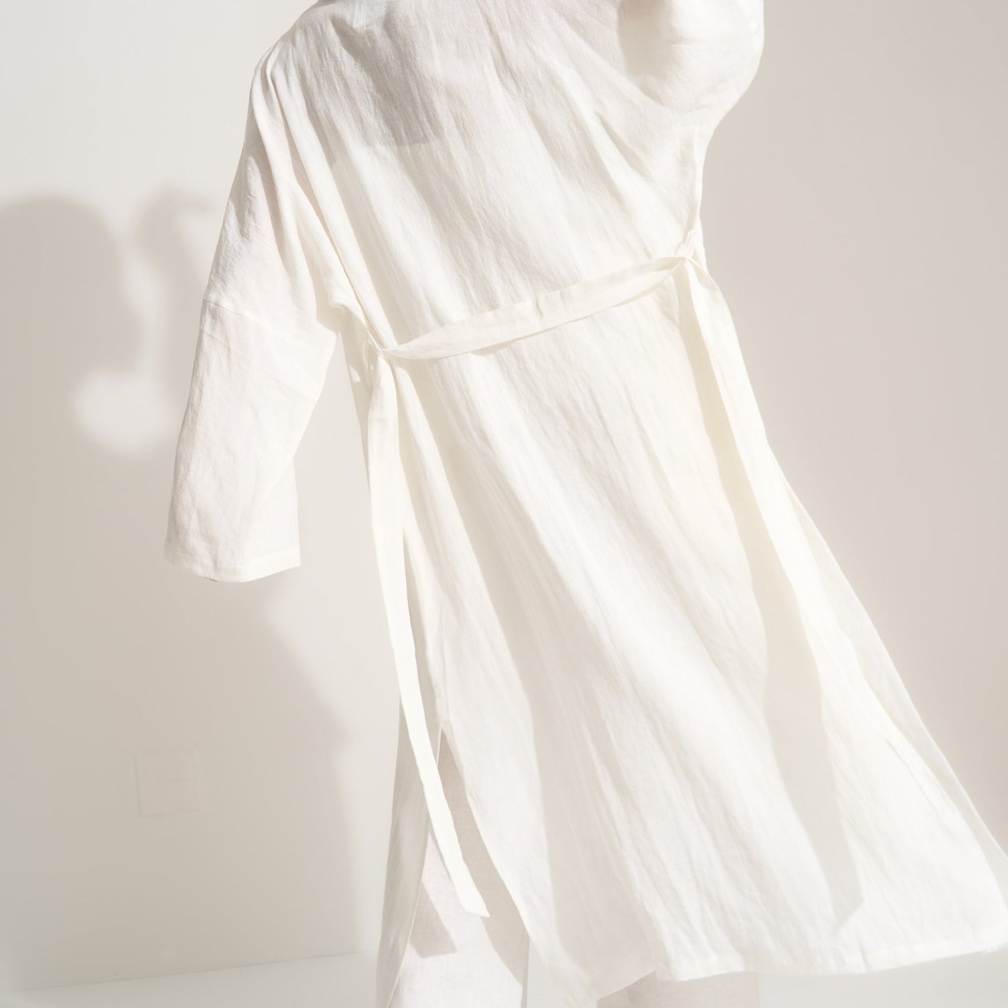 Woman wearing a white outfit against a plain background