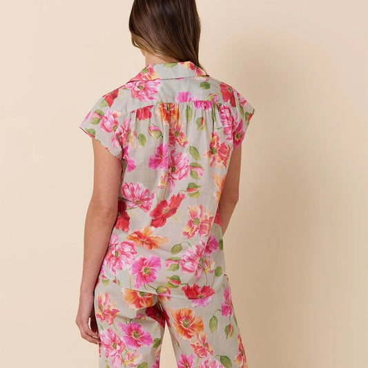 Woman wearing a floral pajama set on a beige background