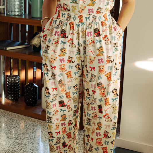 Person wearing pajama pants with a colorful bear and bow pattern indoors.