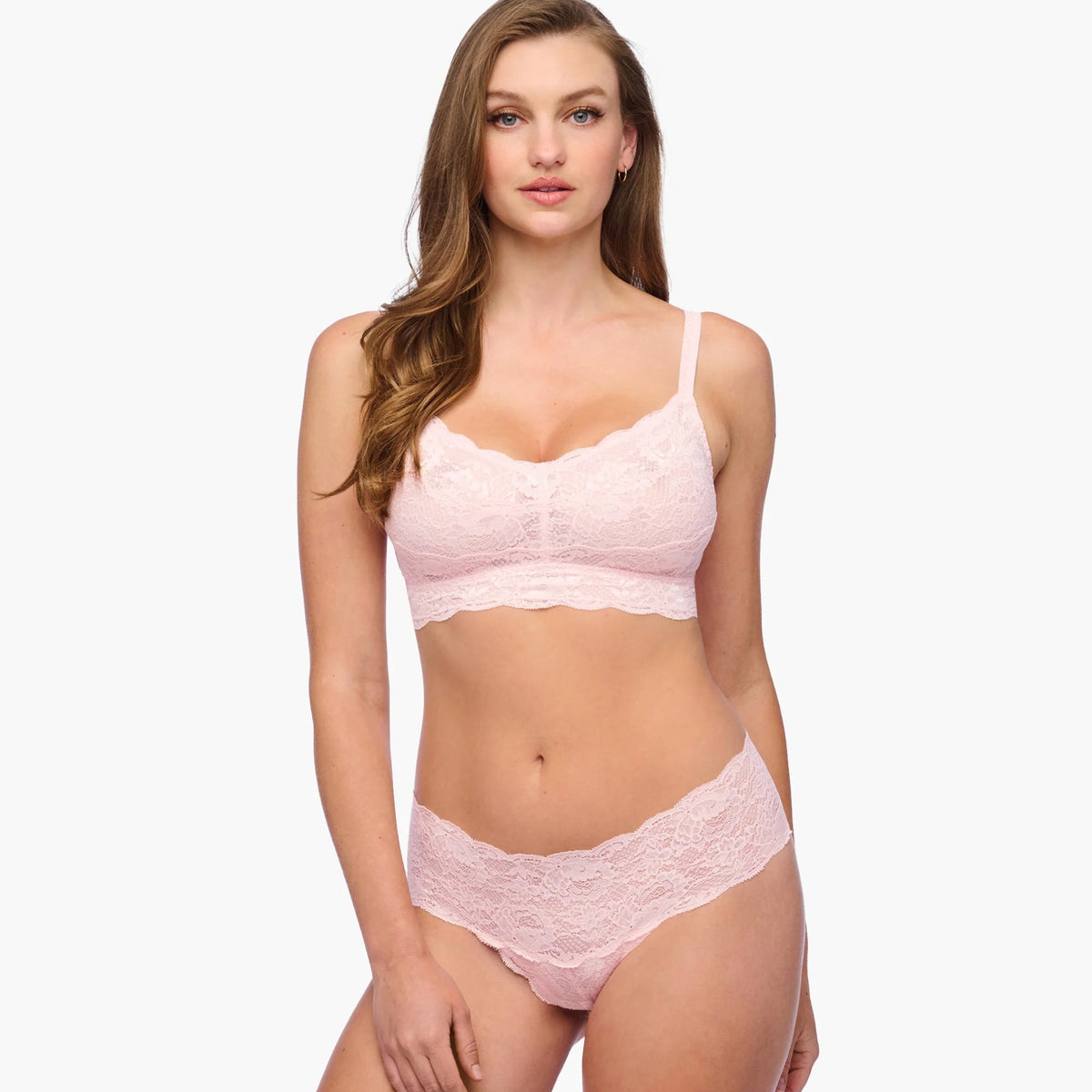 Woman wearing a pink lingerie set on a white background