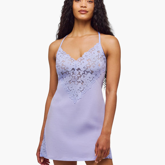 Woman wearing a light purple lace nightgown on a white background