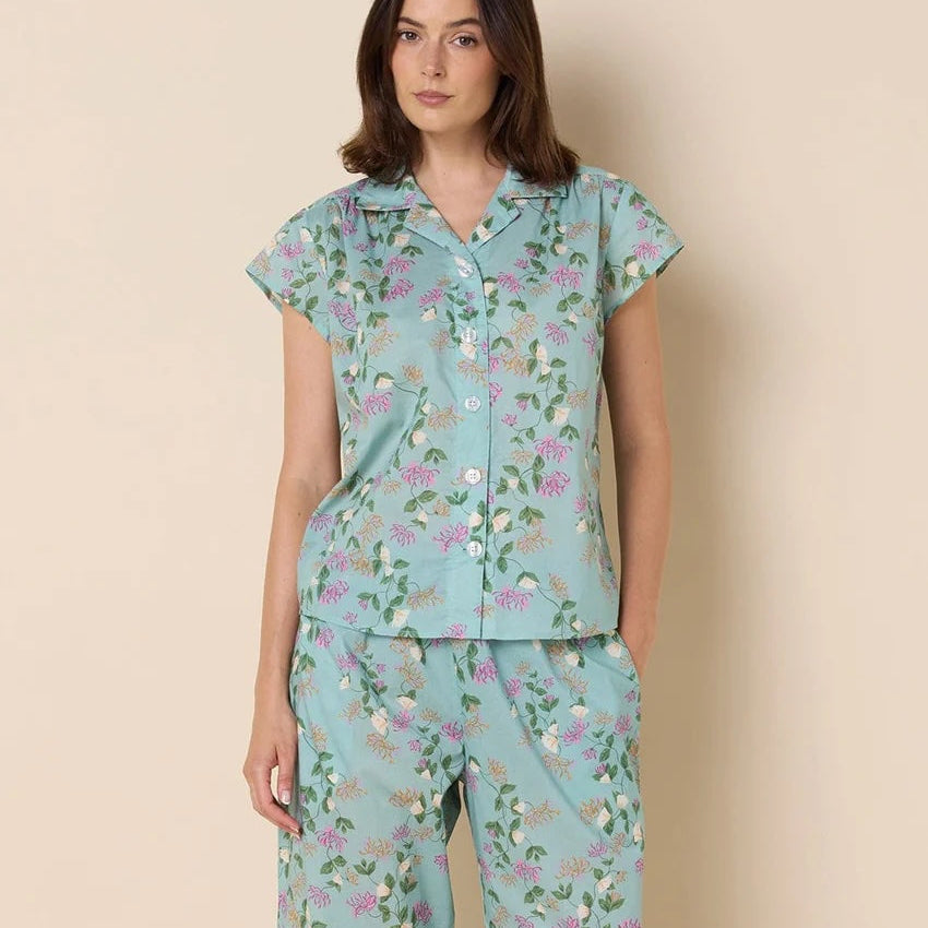 Woman wearing a floral pajama set against a beige background