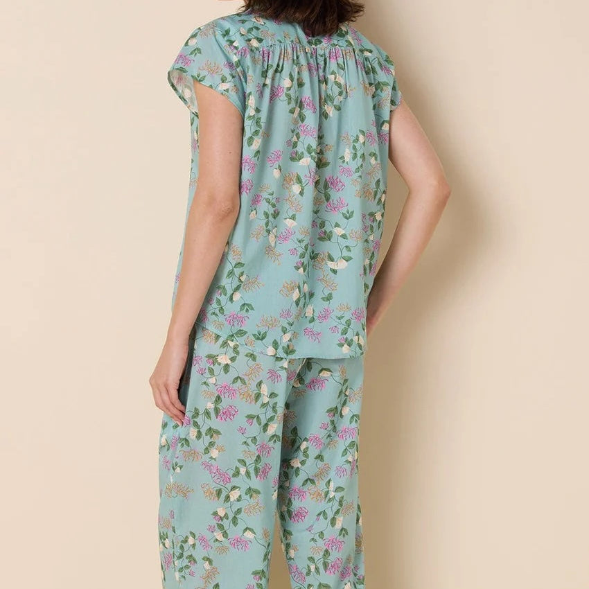 Woman wearing a floral pajama set on a beige background