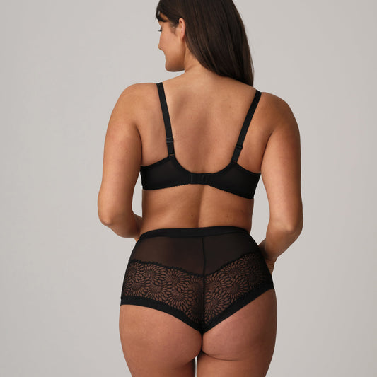 Woman wearing a black lingerie set on a plain background