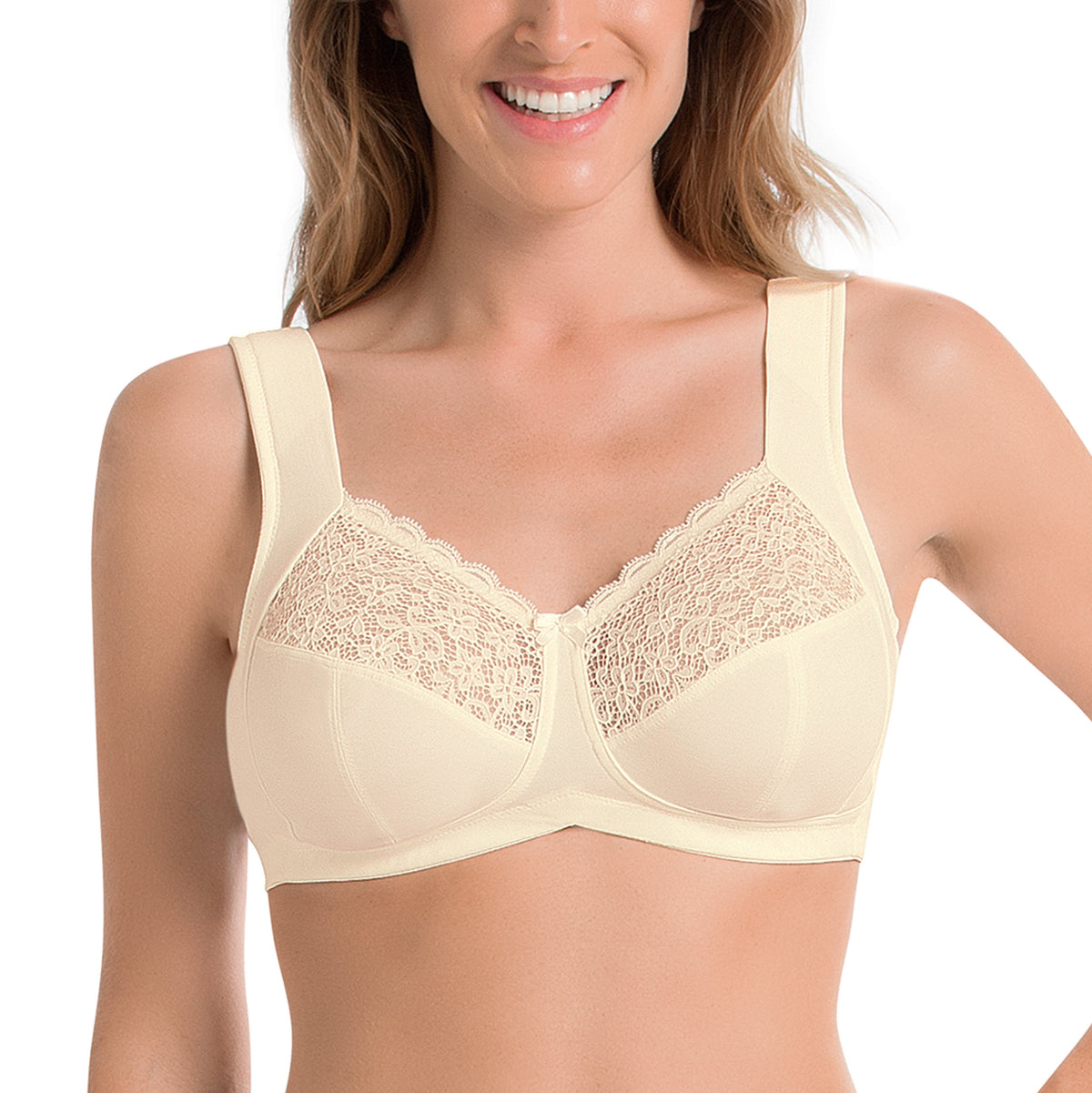 A woman wearing a beige, support wireless bra with lace detailing.