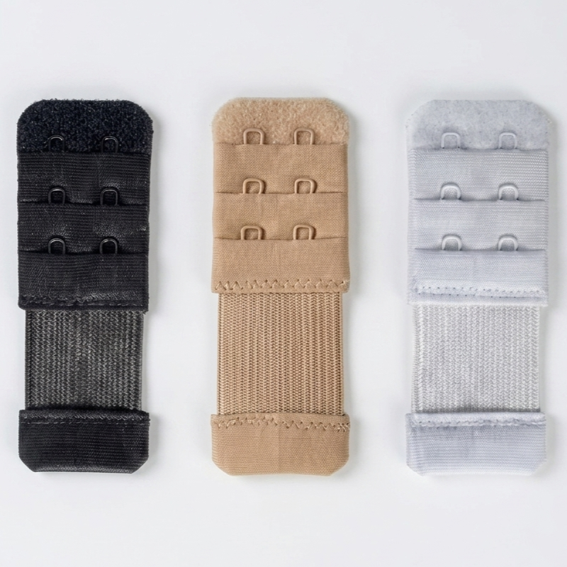 Three hook-and-loop strap adjusters in black, tan, and light gray, arranged vertically on a plain white background.