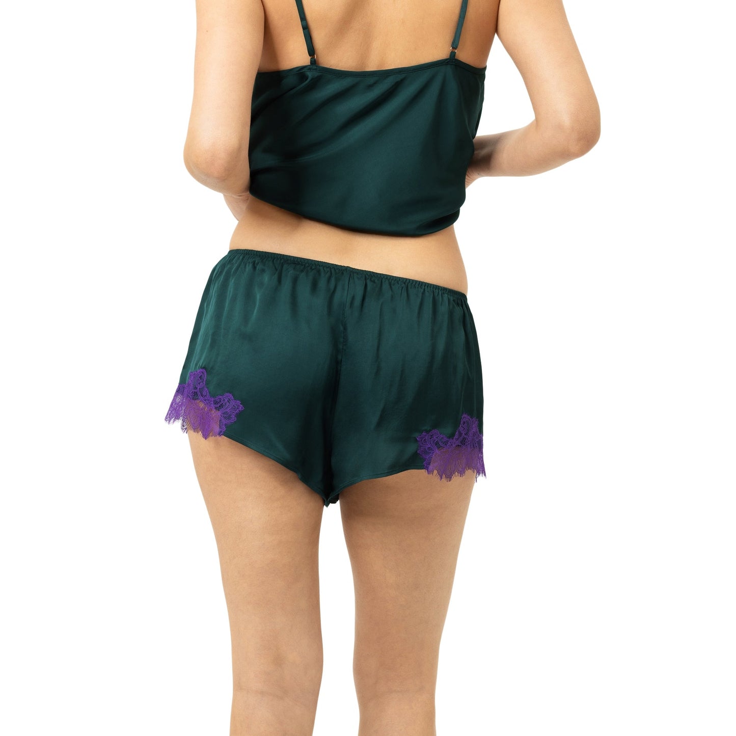 A woman shown from the back wearing a dark green two-piece lingerie set with purple lace trim on the shorts, against a plain white background.