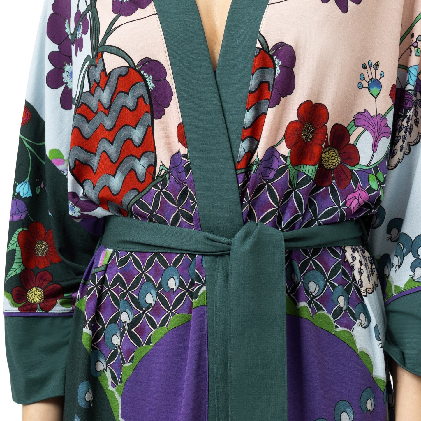 A close-up of a patterned wrap dress or kimono-style robe with a matching waist tie. The fabric features a multicolor print with red, purple, green, and gray motifs on a pale pink base, with solid dark green trim and tie belt.