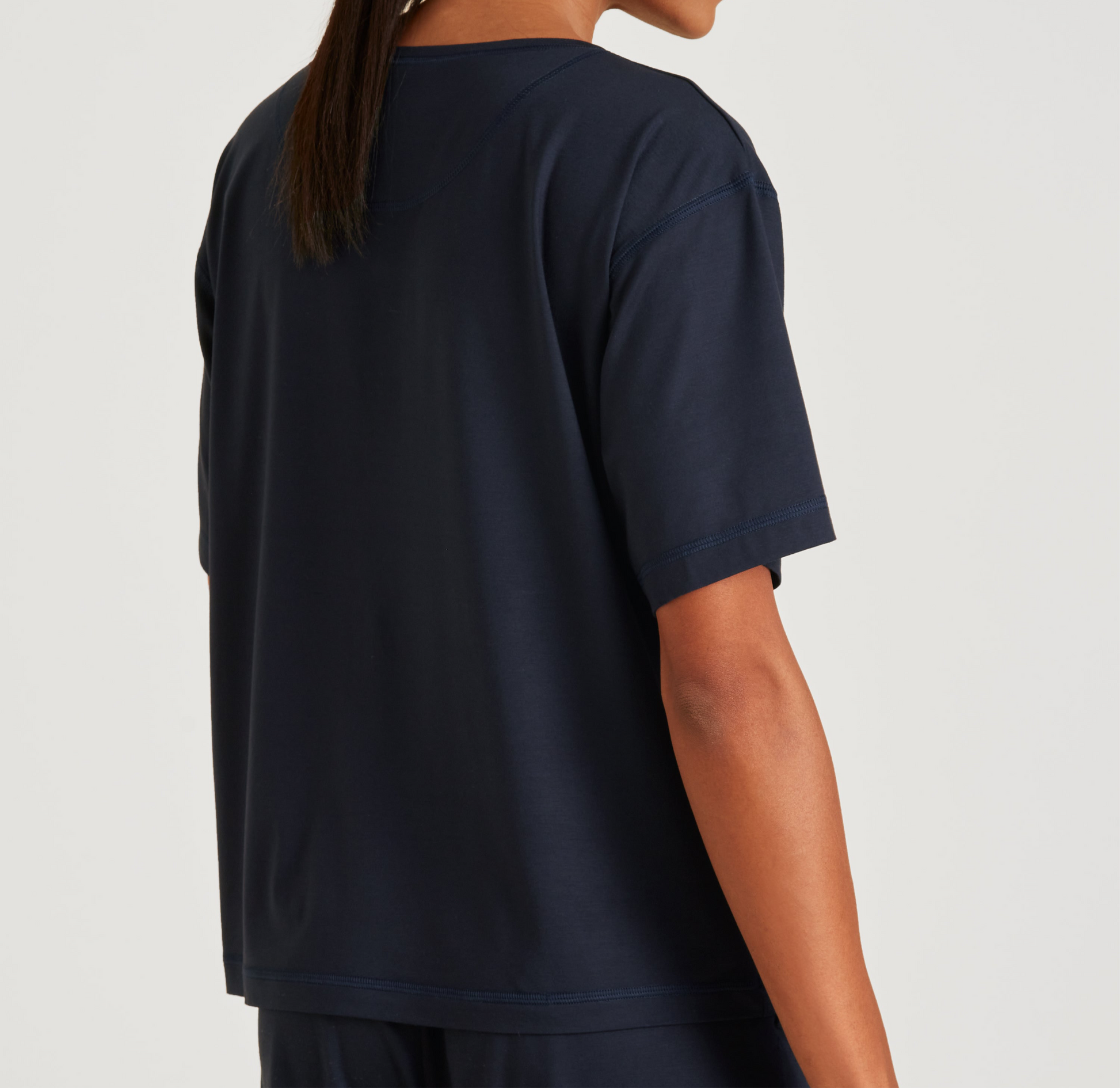Person wearing a navy blue t-shirt on a light gray background
