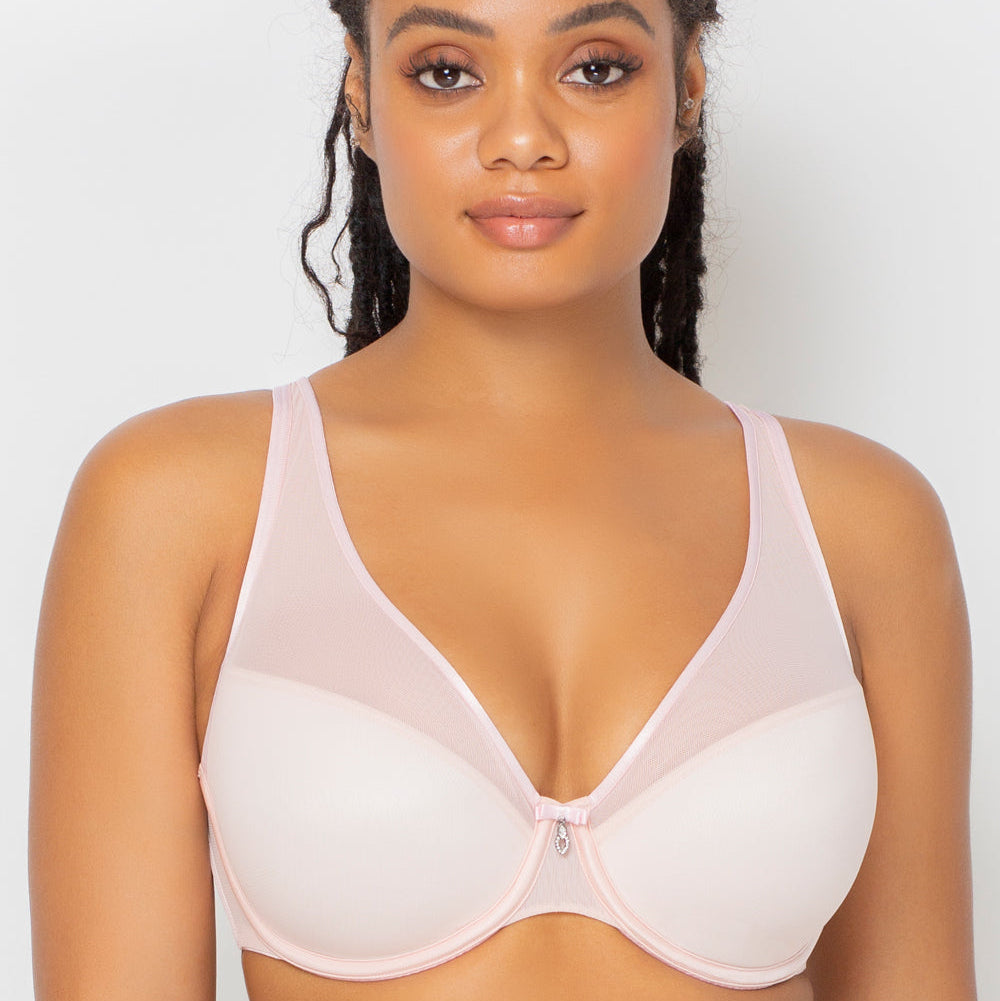 Woman wearing a light pink bra against a white background