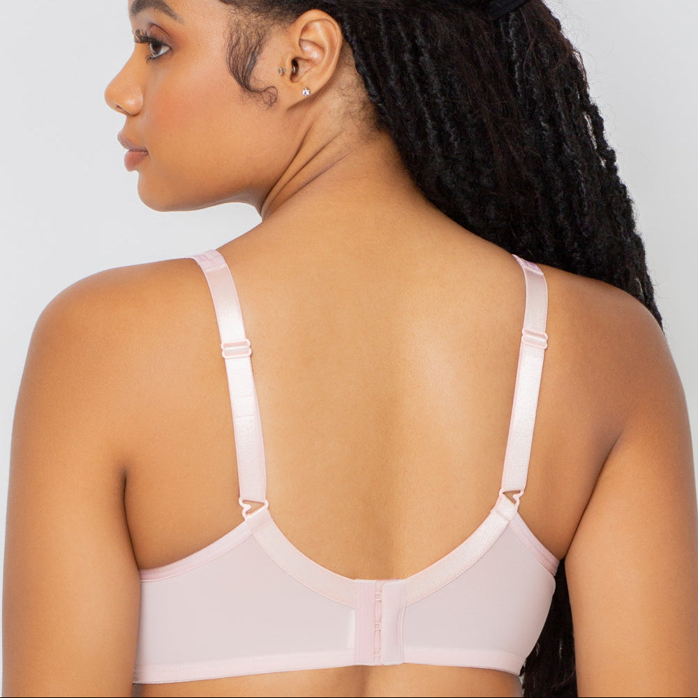 Woman wearing a white bralette against a light gray background